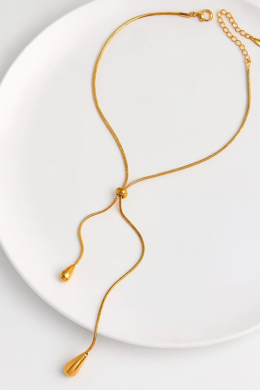 Gold necklace on a white plate