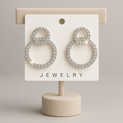 Pair of silver hoop earrings on a jewelry display card with a beige background
