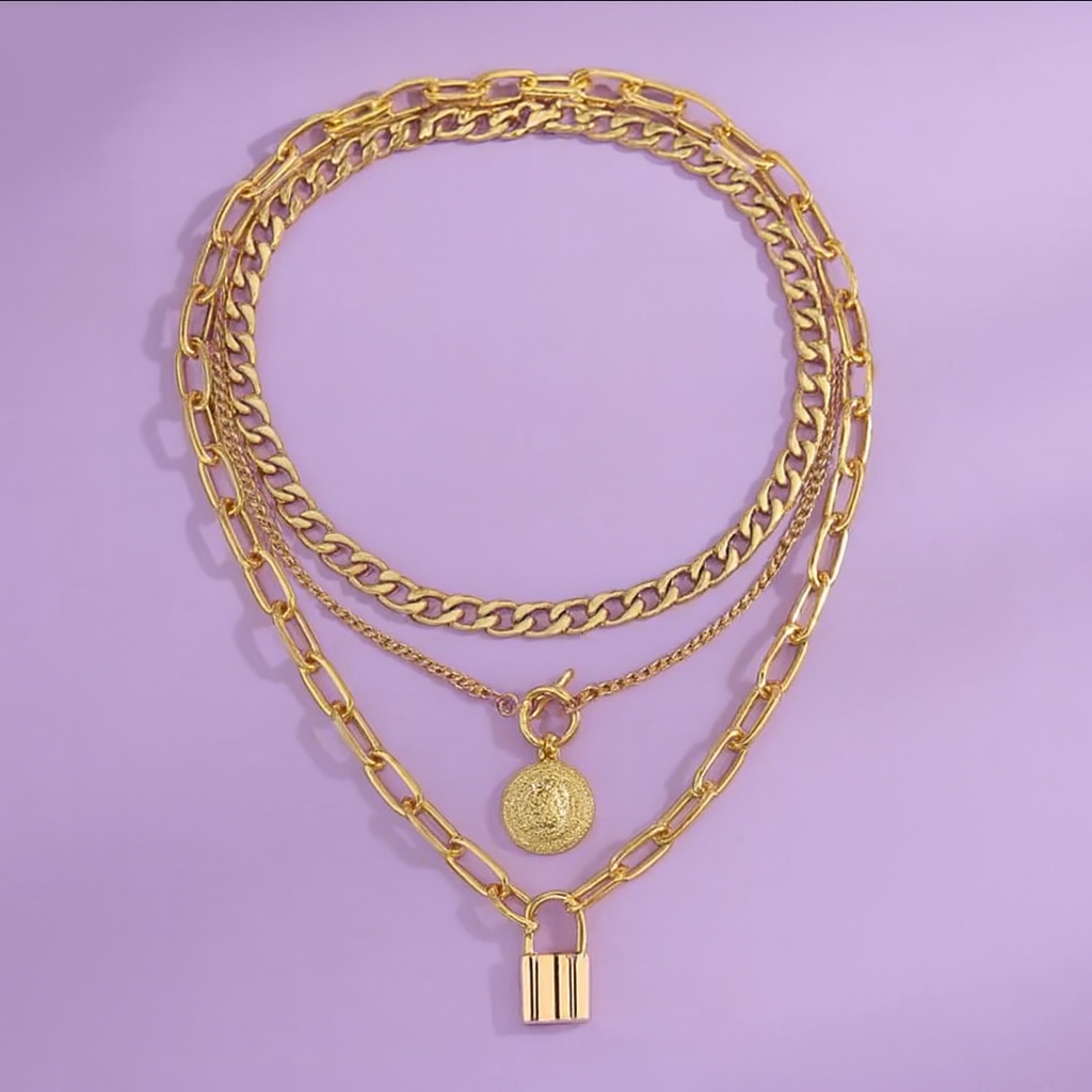 Gold chain necklace with padlock charm on a purple background