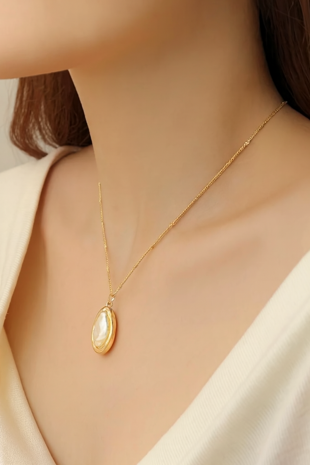 Gold necklace with a pendant on a mannequin